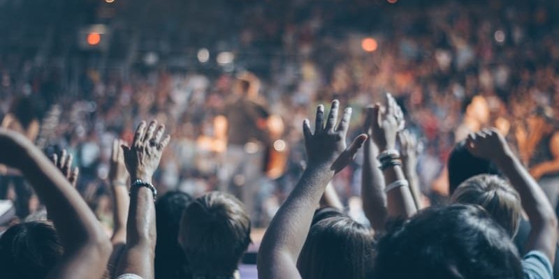 A group of church members raise their hands at a concert fellowship event