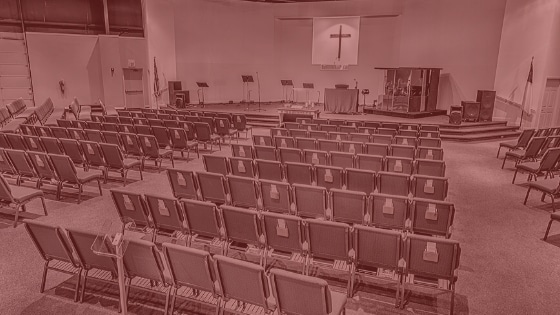 An image of rows of church chairs with a red tint