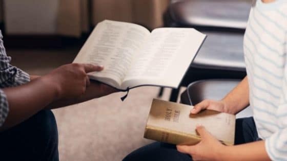 Two people meet for Bible study in a church multipurpose room