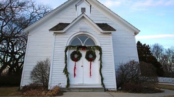 The exterior of a church decorated with evergreen wreaths for Christmas