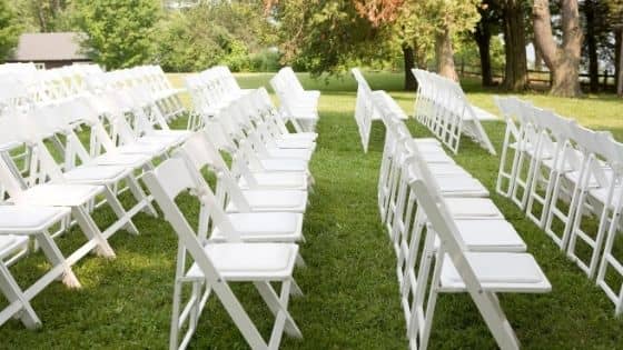 White folding chairs set up in rows for a wedding