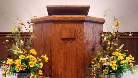 A wooden pulpit with yellow flowers on either side